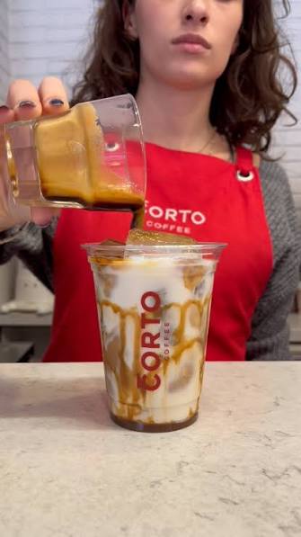 Barista buzlu latte üzerine espresso döküyor